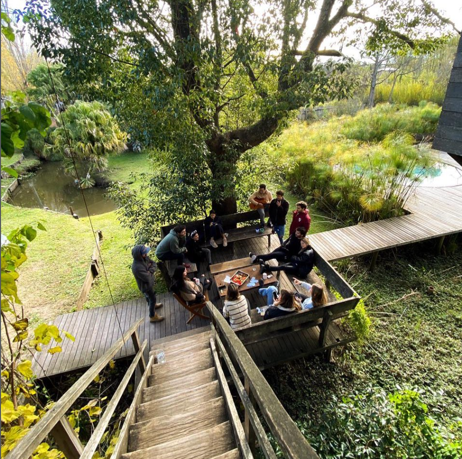 Grupo de amigos en el deck de Casarbol con el arroyo de fondo